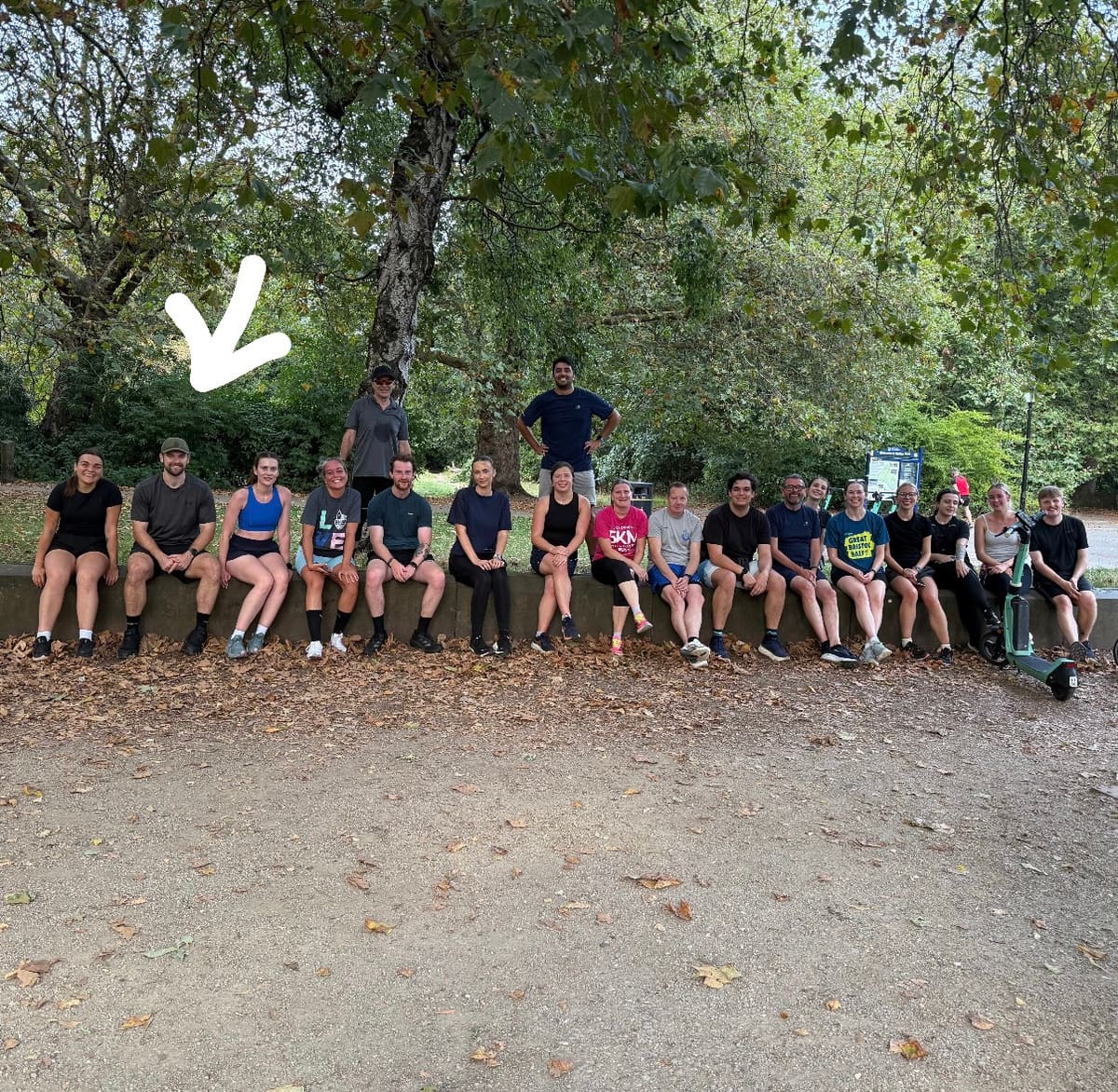 Members of a running group gathered outdoors in a park