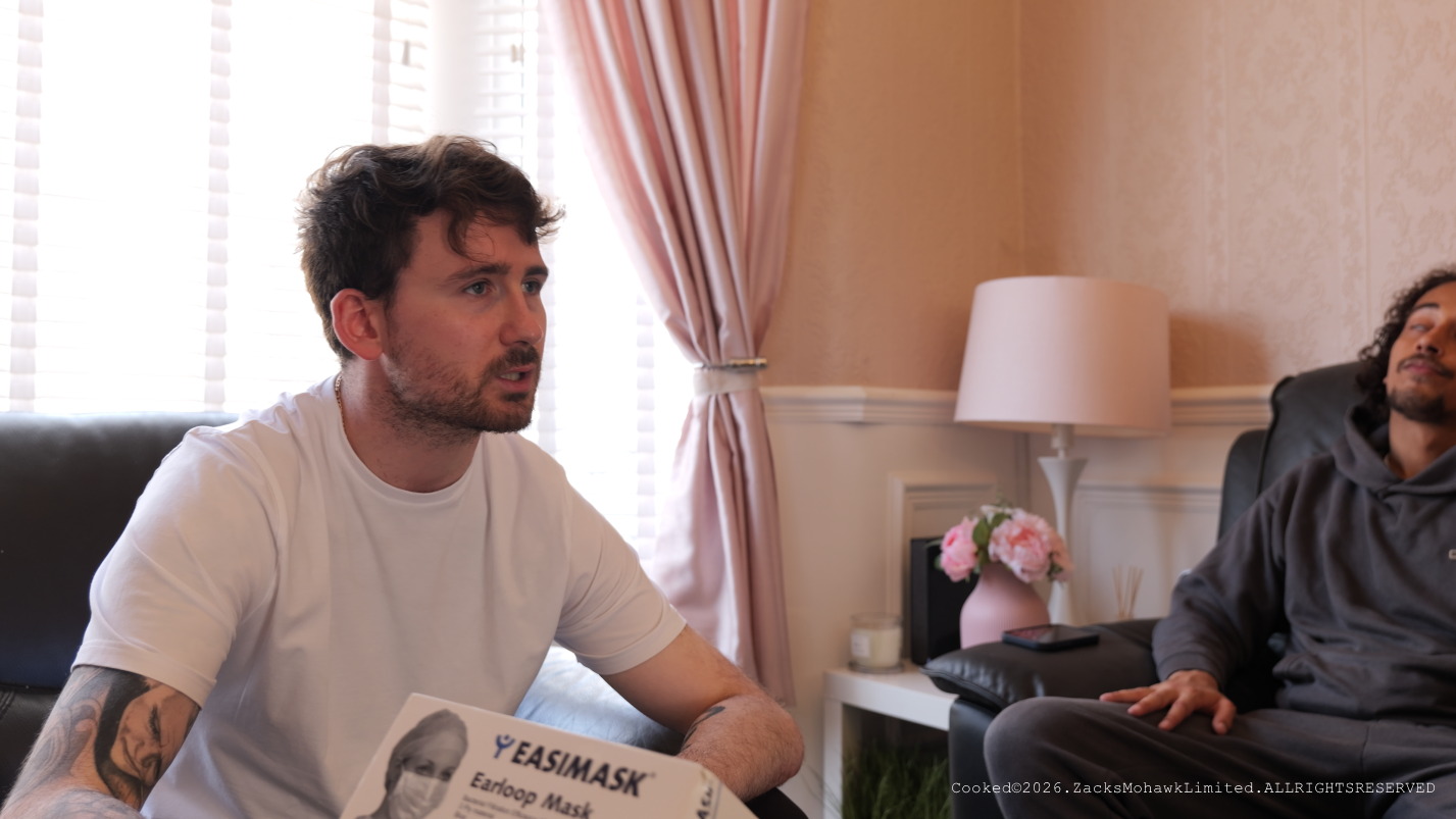 Two characters in a living-room scene from Cooked